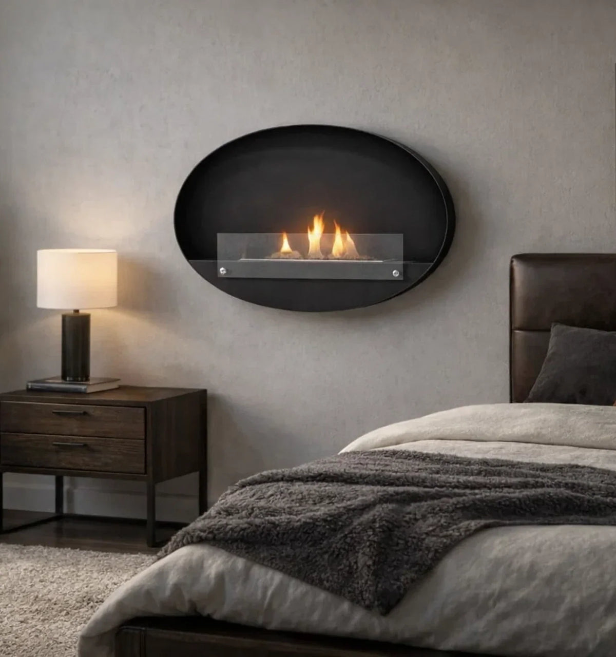 Maryland oval black bio fireplace mounted above a bedside table in a bedroom, lit with a realistic flame