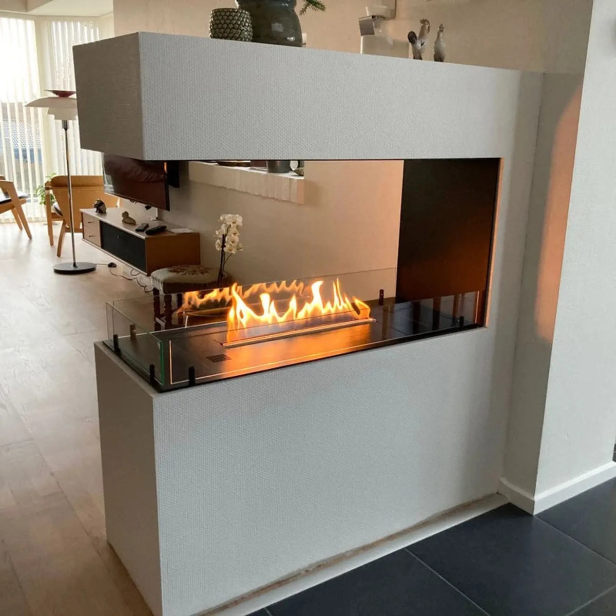 Foco Room Divider 1000 built into a white plastered room divider with lit flame, customer photo