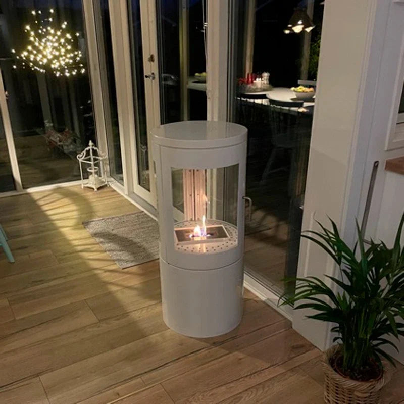 Columbus White Bioethanol Stove with 360-View lit in a real customer's kitchen/dining space at night